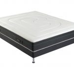 Un matelas avec Matelas mousse alvéolaire avec 5 zones de confort. Avec un sommier en tissu gris.